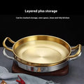 Golden stainless steel wok pan with brass handles on wooden base, showcasing layered storage design for space-saving kitchen 