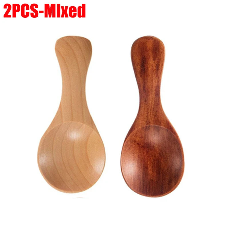 Two wooden mini scoop spoons in natural and dark wood, perfect for tea, honey, and coffee measuring.