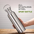 Stainless steel sport bottle with handle, held in hand against wooden surface, silver finish, 500-1000ml capacity
