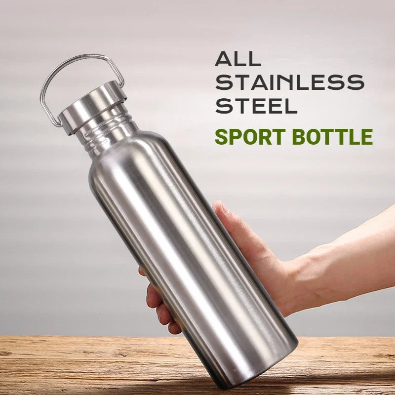 Stainless steel sport bottle with handle, held in hand against wooden surface, silver finish, 500-1000ml capacity