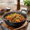 Cast iron double-handle wok with beef and vegetable stir-fry, sesame garnish, surrounded by spices and fresh herbs on wooden 
