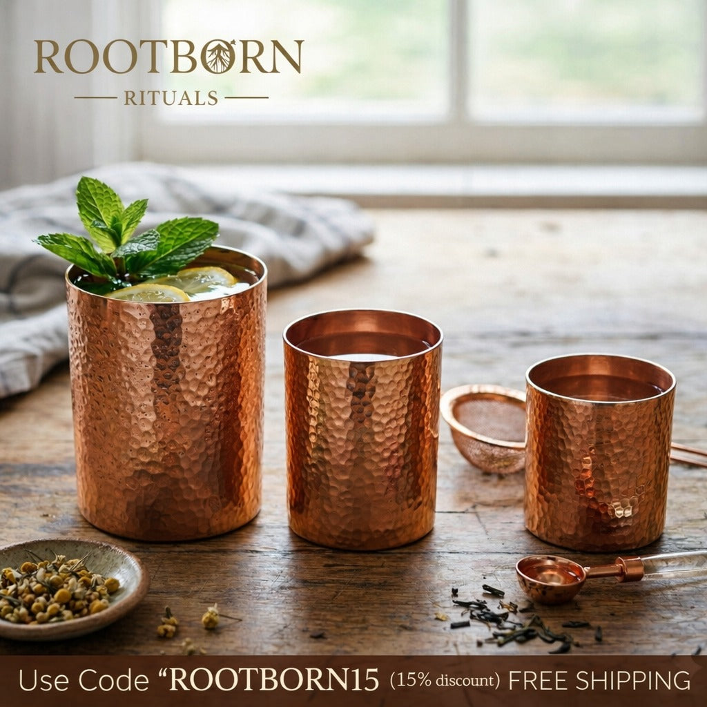 Handcrafted copper mugs with hammered texture in three sizes, filled with mint beverage, displayed on wooden surface with her