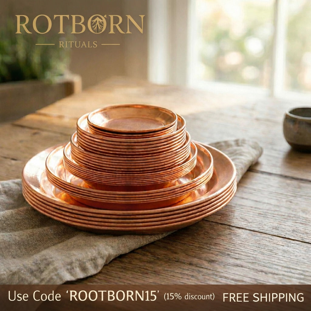 Handcrafted pure copper dining plates in nested sizes, displayed on neutral fabric with natural wood table and plant backgrou