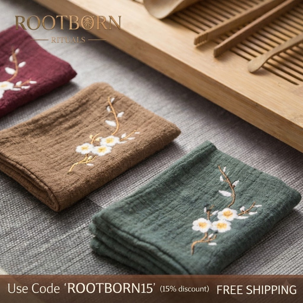 Organic cotton embroidered cleaning cloths in brown and green with white floral designs, displayed with wooden combs on gray 