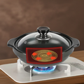 Black ceramic clay pot with glass lid on white gas stove base, glowing red heating indicator panel, blue flame visible beneat