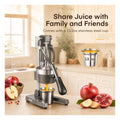 Manual cast iron citrus juicer on a kitchen counter with the removable 400ml stainless steel collection cup shown inset
