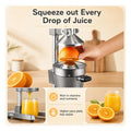 Close view of a halved orange seated on the strainer cone as the press extracts juice